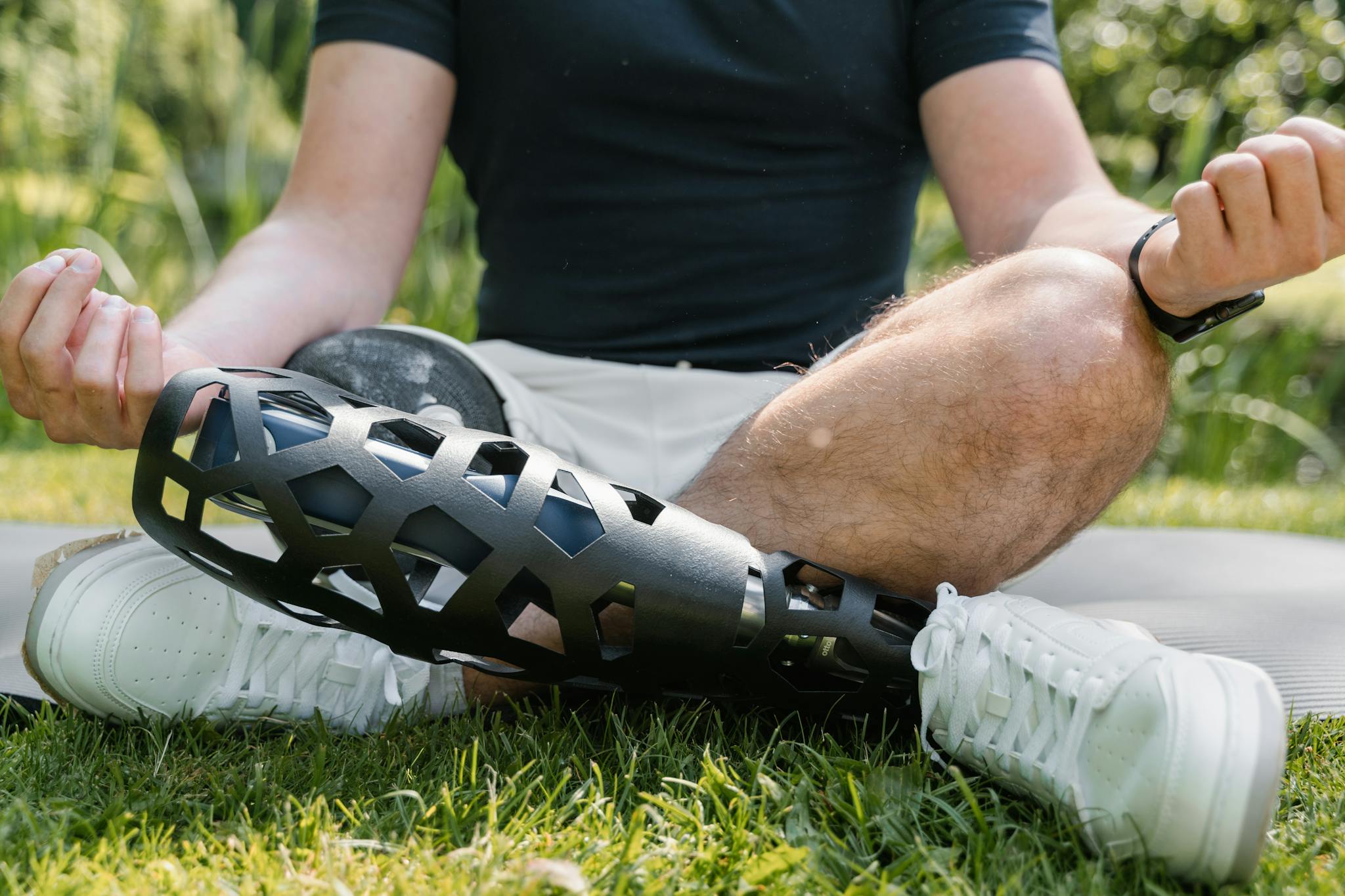 Man meditating outdoors with a modern prosthetic leg, embracing wellness and relaxation.